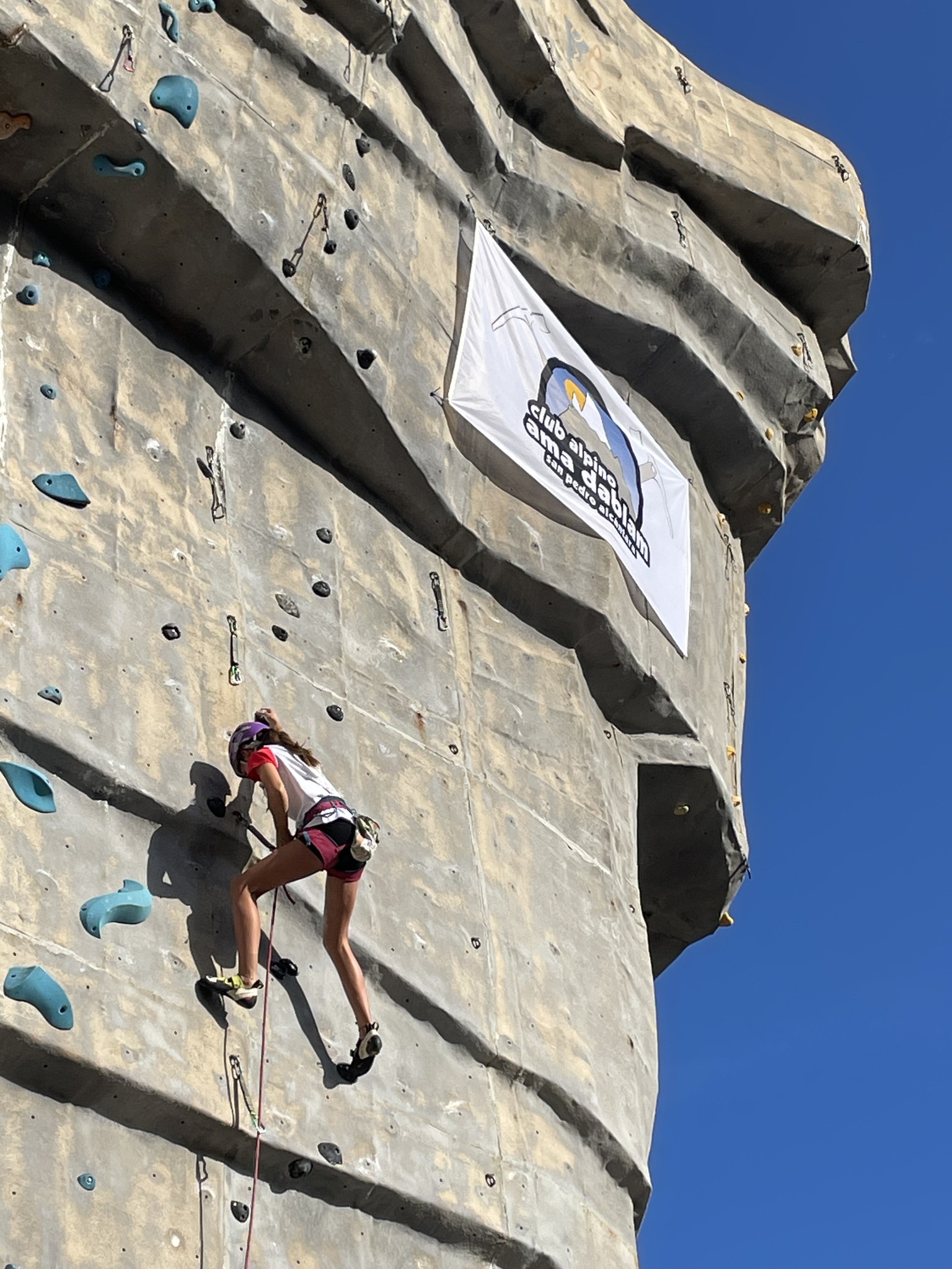 Escaladora ascendiendo el Tornillo con la bandera del Club Alpino Ama Dablam